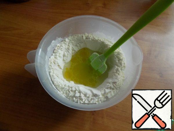Make a well in the flour and pour in warm water. Add olive oil. I always add only olive oil! First, knead the dough with a silicone spatula, then work with your hands. The dough does not stick to your hands, it is soft and pliable.
