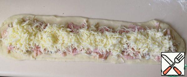 Lay the ham on the mayonnaise. Cheese on ham, also leaving the edges of the dough free.
