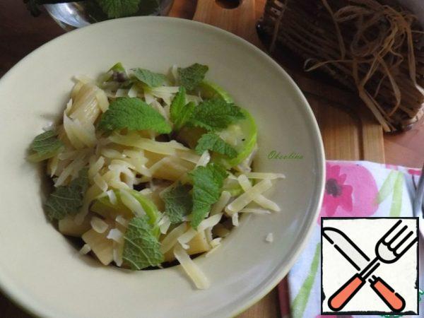 Serve by placing the pasta with zucchini in a bowl. Top sprinkle with Parmesan and lemon balm or mint leaves.