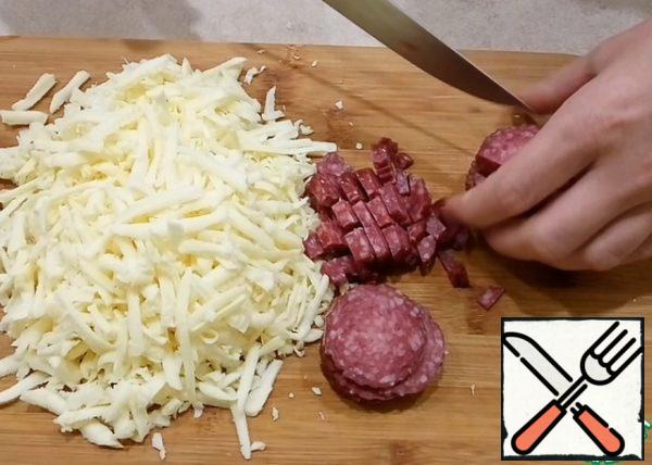Grate the cheese on a coarse grater (I use Suluguni cheese) and finely chop the sausage or ham.