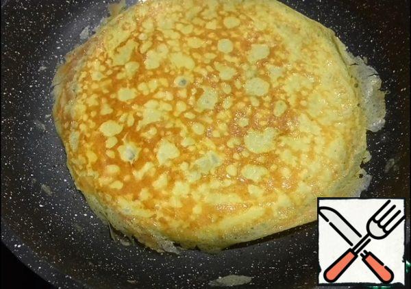 Prepare pancakes, it is necessary to whisk the eggs with milk and salt. Heat the pan, add vegetable oil. Distribute one incomplete scoop of egg-milk mixture over the entire surface, fry on both sides until Golden brown. This number of ingredients is designed for three pancakes.