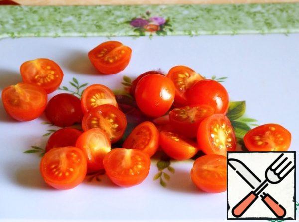 Wash the tomatoes and cut them in half.
