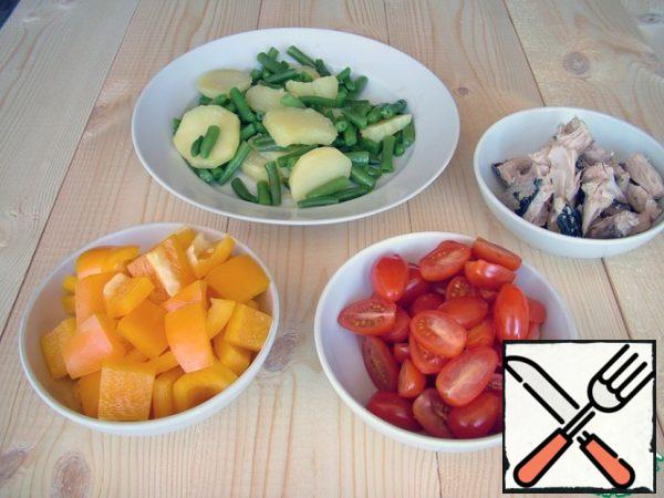 The salad, if necessary, is washed and cut into large pieces, I buy ready-made, which does not require washing. Cherry tomatoes cut into halves, pepper - medium-sized pieces. Potatoes, sliced, and beans are boiled together for 7-8 minutes until soft. I flip it into a colander.
Cut the tuna into pieces.
