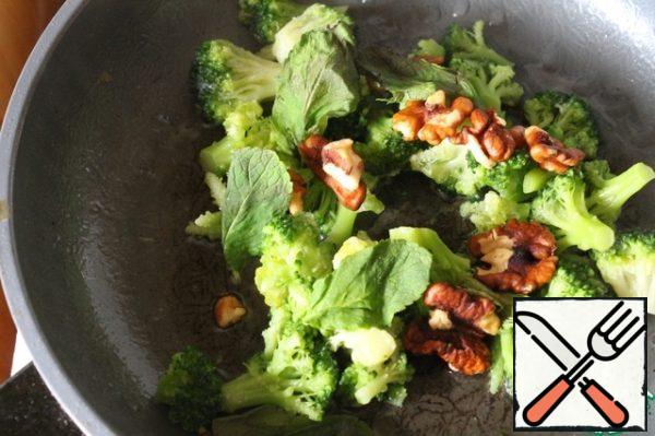Lightly fry broccoli in vegetable oil with walnuts.
