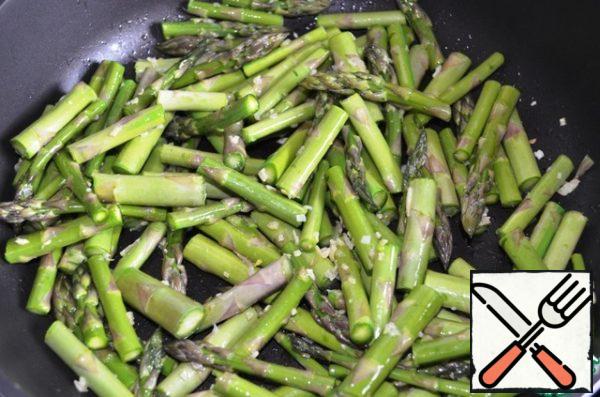 Add the prepared asparagus and fry everything over medium heat (under the lid) for about 3 minutes.
