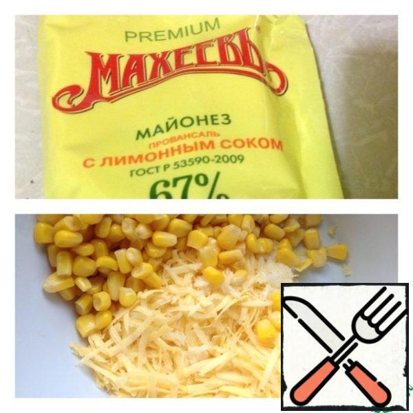 In a salad bowl, put half a can of corn (drain the excess liquid) and cheese, grated on a medium grater.

