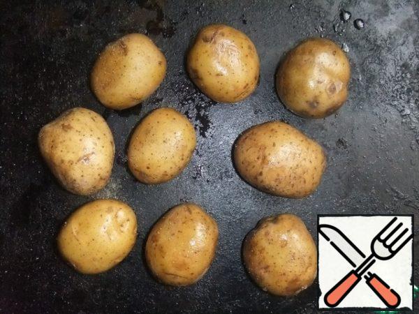 Wash potatoes thoroughly, sprinkle a little with olive oil - and on a baking sheet.