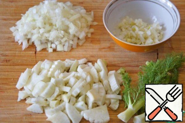 Finely chop the onion. Cut off the feathery tops of the fennel and leave to decorate the soup. Cut the bulbs into 4 pieces. Cut one quarter very finely and put it in a bowl with lemon juice, mix well. Cut the rest of the fennel into arbitrary pieces.
