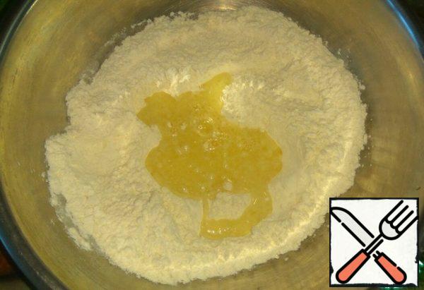 In flour add yeast and salt, mix. Pour parts of the milk mixture.