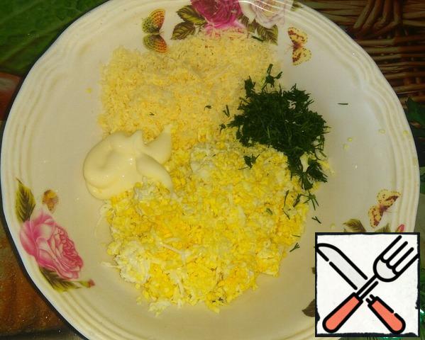 Prepare the stuffing.
3 eggs boil hard.
Grate cheese and eggs on a small grater.
Finely chop the dill.
Combine all in a bowl, adding salt and mayonnaise.
