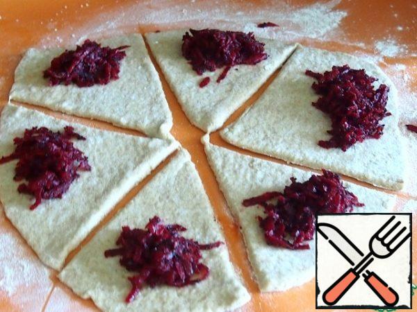 Divide the dough into three parts. Roll out each part into a circle, divide the circle into triangles. Put the filling on the triangles with wide sides
