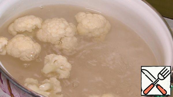 Wash the cauliflower, disassemble it into inflorescences.
2 liters of boiling water, salt to taste. Lower the cauliflower into boiling water and cook for 2-3 minutes.
