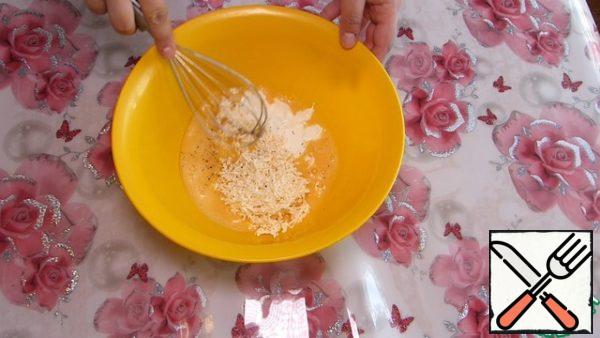 Meanwhile, grate the melted cheese on a fine grater.
In a bowl, whisk the eggs, beat lightly with a whisk;
add melted cheese, sour cream, salt, ground black pepper.
Mix it.