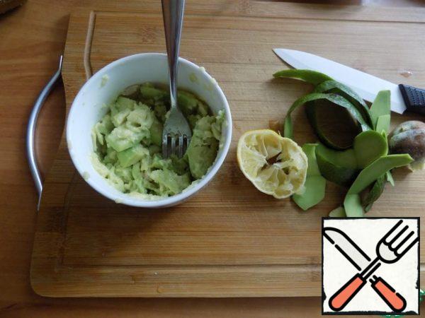Avocado clean and remove the bone. I'm going to press the avocado with a fork to make the smear feel like pieces of it. Cut into small pieces of avocado ceramic knife (so it quickly does not darken), placed in a ceramic bowl and one lemon wedges squeezed juice directly into pieces. Using a fork, crush the avocado in weight.