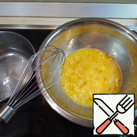 At the first stage, the eggs will be whipped in a water bath. To do this, pour some water into a saucepan and bring to a boil. In a bowl with a whisk to connect eggs with sugar and vanilla. Put on a saucepan with water so that the bottom of the bowl with eggs does not touch the water.