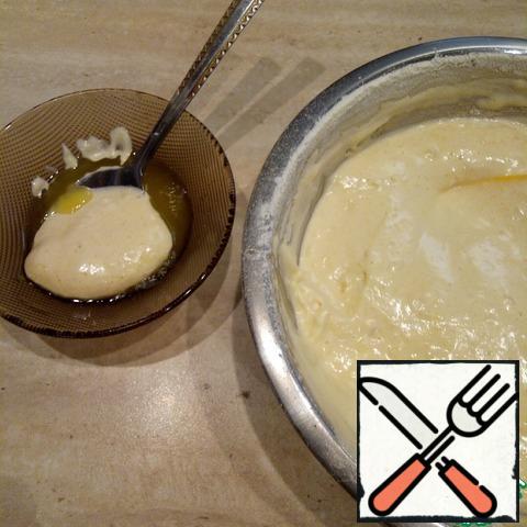 In the prepared butter, add a spoonful of dough and mix well.
