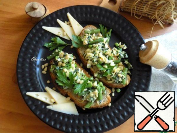 Take a nice plate and spread the toast, too, beautifully decorated them. Sprinkled toast with pine nuts, decorated with parsley leaves, added cheese favorite!