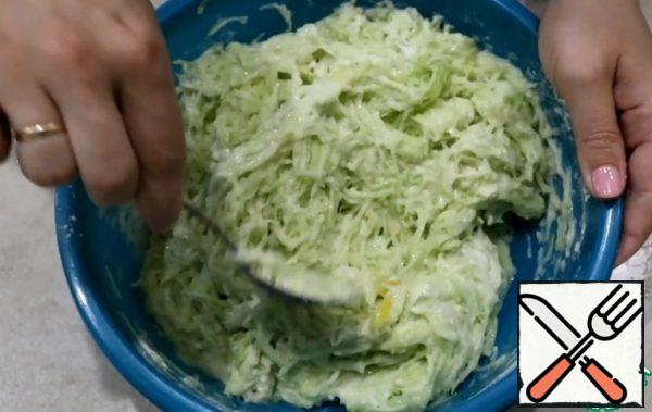 In a deep bowl, grate the zucchini on a fine grater. If zucchini are young, then I do not remove the skin. Add egg, salt, yogurt and flour. All mix well. Dough is ready.
Add about 3 tablespoons of squash dough to a hot pan with vegetable oil and spread evenly over the surface of the pan. After a minute on one edge of the pancake put a spoonful of chicken with onions.