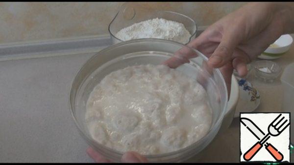 For the starter, grind the yeast, add 1 tablespoon of sugar and 1 tablespoon of flour from the total norm, pour 150 ml of warm milk, mix and leave for 10-15 minutes.
