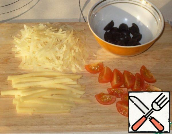 Onions to chop, garlic to clean.
Cut hard cheese into slices and then into strips.
Tomatoes, cut into quarters, black olives in half.