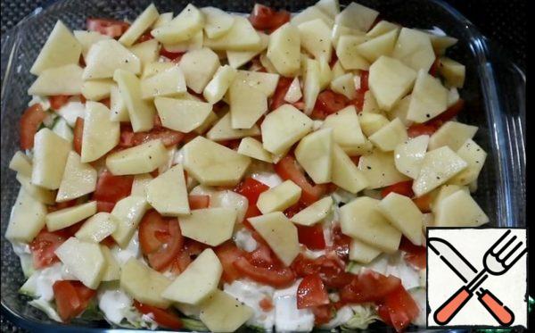 Next, spread the zucchini and smeared with sour cream and garlic sauce, put tomatoes on top and cover with potatoes.