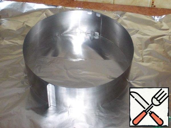 If you have a split form, you skip the next two steps. If you use a split ring like me, this information is for you, and these two steps are mandatory! In order to wrap the ring with foil, you will need a piece of foil measuring 51 by 51 cm. This is based on a ring diameter of 30 cm and a side height of 10 cm. If the foil roll you are using is not wide enough, then tear off two pieces and put one on top of one.
