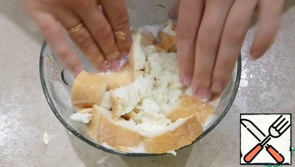 Cut into 4 slices of loaf, pour milk, a little mash hands and leave for 10-15 minutes until the loaf is completely soaked.