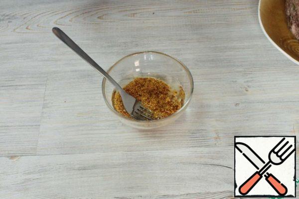 For the marinade, chop the remaining 4 garlic cloves through a press. Mix garlic, grainy mustard and vegetable oil. Mix well.