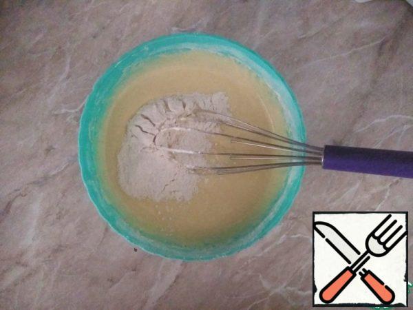 Then, in the resulting mass, add a mixture of flour, baking powder and sugar, and mix well. You should get a dough like the consistency of thick sour cream.