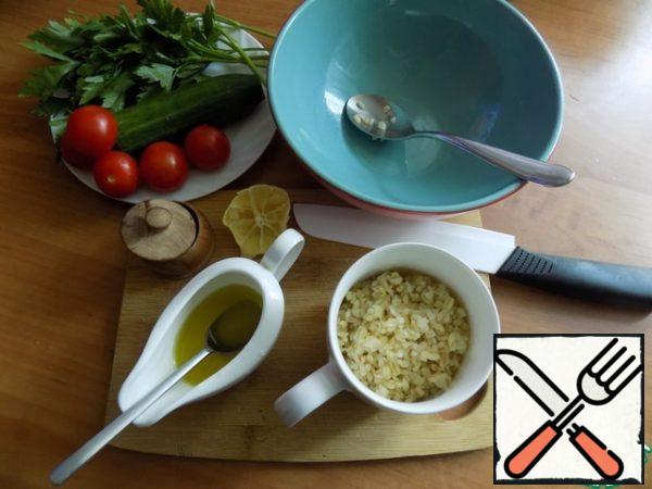Bulgur should be prepared in advance or, if it is small, then steamed. It should be warm. I am tired of Bulgur, so that he is beautiful. We are preparing everything I need for my table. I use cucumber, cherry tomatoes and parsley. Prepare the dressing. Mix olive oil and lemon juice. I squeezed the juice out of a slice of lemon.
