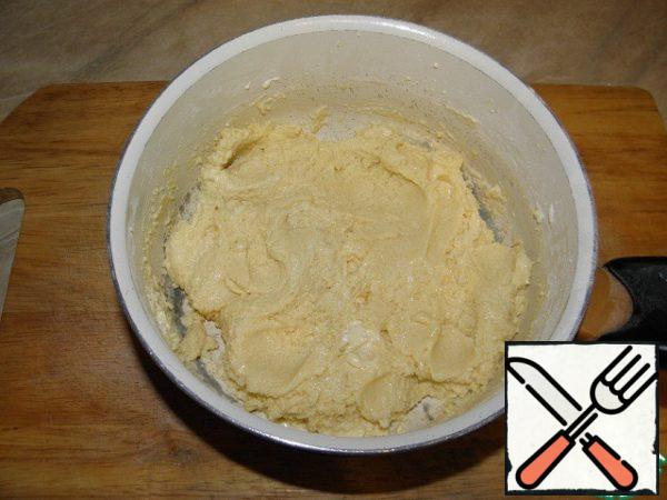 Gradually, stirring constantly, add the flour sifted with baking powder to the beaten egg-sugar yolks.
