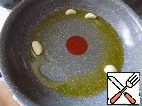 I poured 1 tablespoon of olive oil into a frying pan, warmed it up and put garlic cloves cut in half across. Hold the garlic cloves in the oil for a minute so that they give flavor to the oil.
