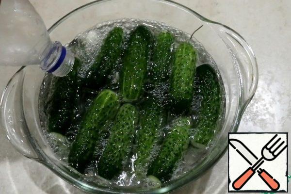 Pour the cucumbers with mineral water and salt and add the rest of the soda. Cover the cucumbers with a plate so that they do not float, and all the time was in the water. A container of cucumbers in the refrigerator.