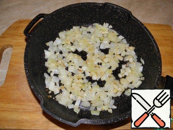 In parallel, we prepare the sauce: finely chopped onion and garlic squeezed through a press are fried in butter.

