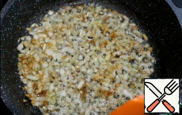 Chop the onion and garlic. Heat the pan with vegetable and butter. Fry onions with garlic, add a pinch of salt and sugar. Fry until Golden brown.