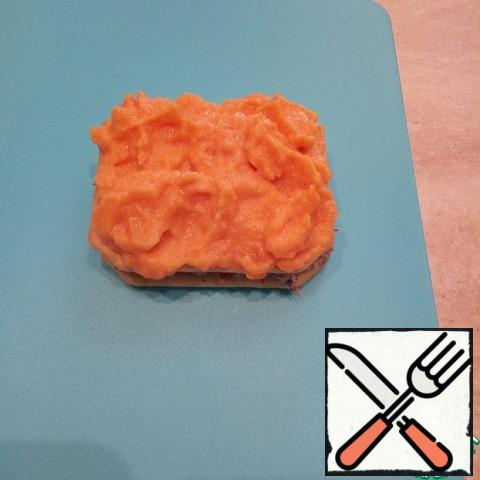 Cover with the second cracker and lubricate carrot paste.