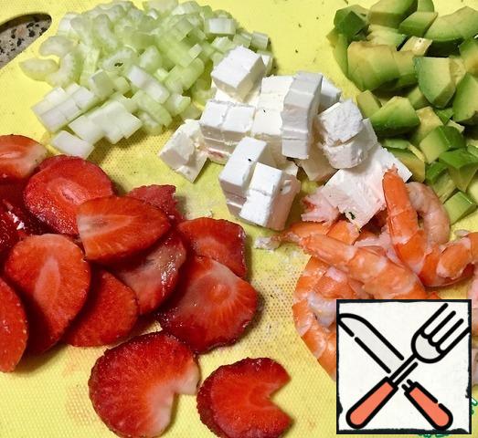 Rice boil until tender. Shrimps to boil, clear. The strawberries cut them into slices. Peel the celery stalk and cut the flesh. Cut the cheese into cubes. Avocado peel and dice.