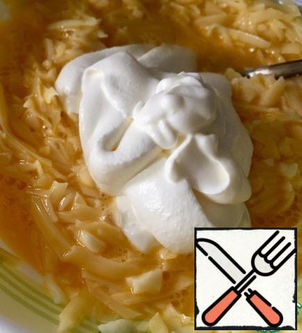 Mix eggs, sour cream, grated on a coarse grater, cheese.