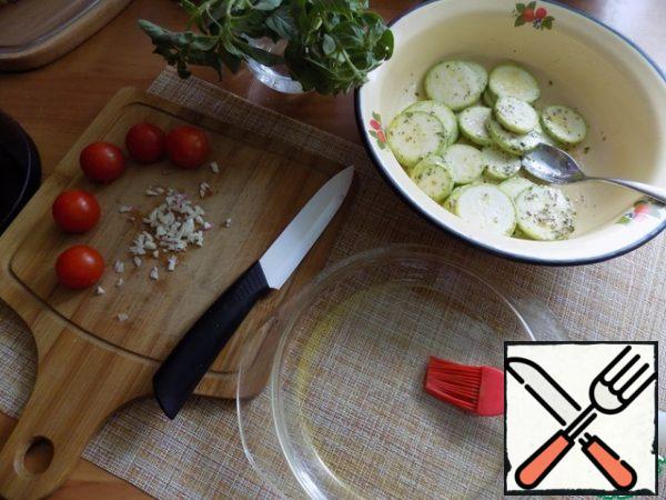 Stir. Garlic finely chop. Cook the tomatoes. I use cherry. Take a suitable form, such a size to fit the slices of zucchini in one layer or overlap. Grease the form of olive oil 0.5 tbs.