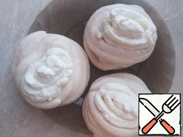 With the help of a pastry bag, fill the baskets with cream.

