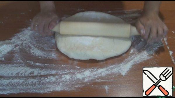 When the dough came up, I took it out and kneaded it a little, sprinkling the table with flour. Leave for 5 minutes, and then roll out into a 5 mm thick layer. Take a cup or glass and squeeze out the blanks for the pies.

