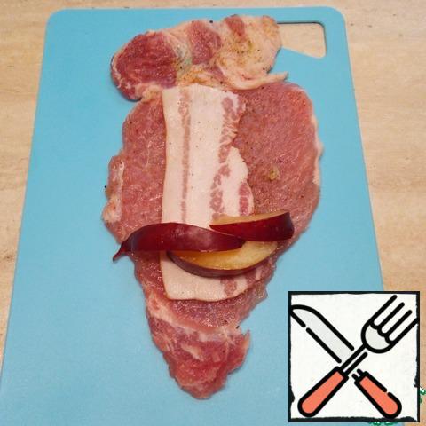 A piece of meat put half strips of bacon. On top of the bacon, closer to the edge of 3-5 slices of plum.
Bacon can take on a stripe, plum is also more-less. It all depends on the taste and size of the piece of meat.