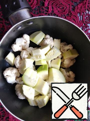 Disassemble the cauliflower into inflorescences, cut the zucchini into cubes. Boil in salted water until soft.