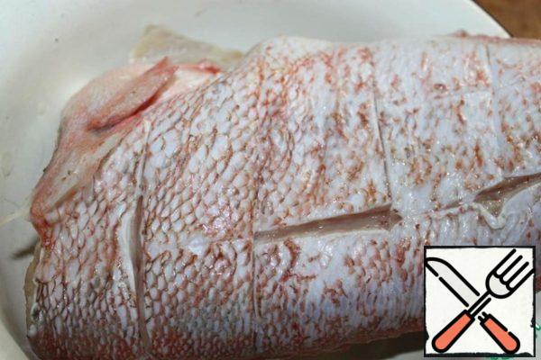 The fish cut off the fins, make on each side of the cuts in the skin. Salt and pepper the fish.