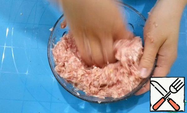Prepare the stuffing. Chop the onion with a meat grinder or blender. Add it to the minced meat. Add salt and pepper, add cold water and mix well.