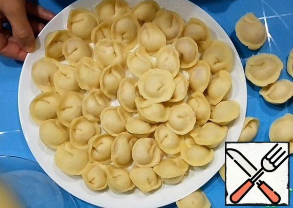 Divide the dough into 4 parts. From each part, form a tourniquet and cut circles 1 cm thick. Roll out the cakes. In the center of each cake, place the minced meat and form a dumpling.