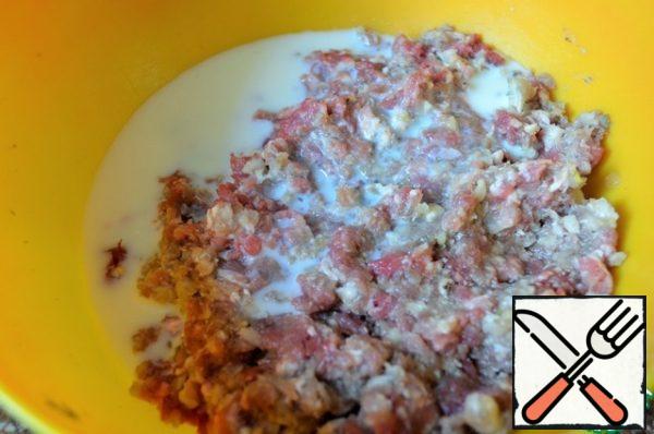 Chop the meat in a meat grinder, add 2/3 onion, pour milk into the minced meat.
