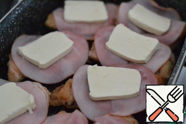 Put a piece of ham on each piece of breast. Place a plate of cheese on top.
