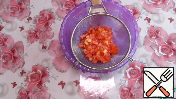 Помидоры нарезать маленьким кубиком. Посолить по вкусу, добавить измельченный чеснок и перемешать. Для того, чтобы слить лишнюю жидкость, выбрасывает помидоры в сито.