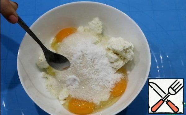 In curd add eggs, salt, sugar and soda. All carefully knead with a fork. Then add vegetable oil and mix.